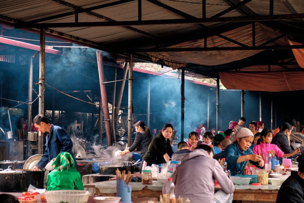 Lively Asian market scene showcasing traditional dining culture with diverse people enjoying food together.